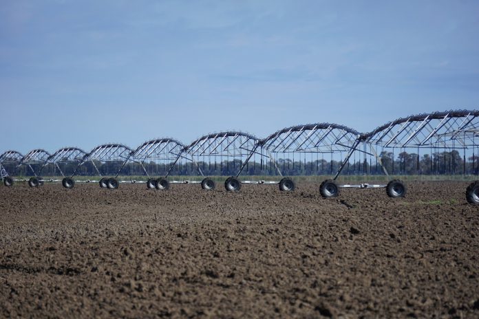 Brasil-consumo-água-economia-R$1-6L-irrigação Irrigador industrial mecânico sobre uma grande lavoura de terra seca