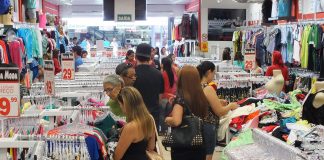 Pessoas escolhem produtos de vestuário em um feira de comércio