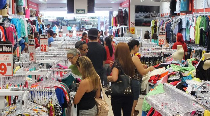 Pessoas escolhem produtos de vestuário em um feira de comércio