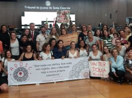 Justiça confirma constitucionalidade da Lei das Doulas Grupo de mulheres posa para foto com uma faixa escrita "Que nada nos defina"