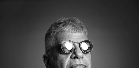 Lulu Santos traz sua nova turnê a Florianópolis Imagem em preto e branco do cantor Lulu Santo usando óculos escuro com o rosto virado para o lado