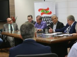 Mesa de reunião com políticos em apenas um lado para coletiva de imprensa