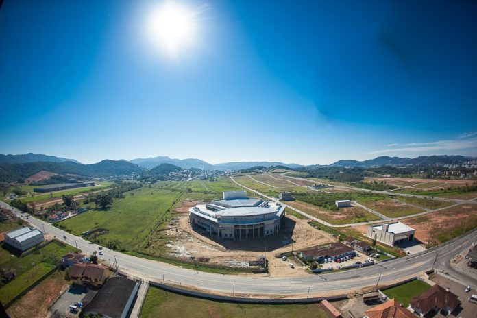 Arena Petry - São José Complexo visto de cima, com rodovia passando à frente e um grande céu azul acima