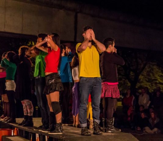 Cia. Rústica traz turnê “Cidade Proibida” para Florianópolis Grupo de atores em pé sobre uma mesa preta com as mãos tapando olhos, bocas e narizes
