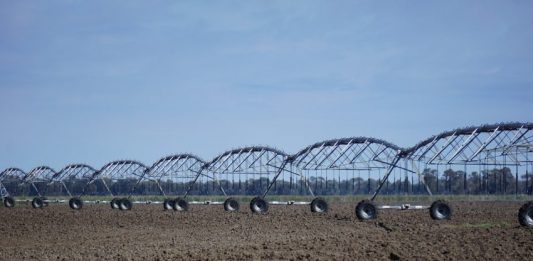 Cada R$1 produzido pela Economia exige 6 litros de água Irrigador industrial mecânico sobre uma grande lavoura de terra seca