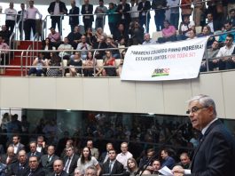 Governador Pinho Moreira fotografado de lado discursando para a assembleia lotada