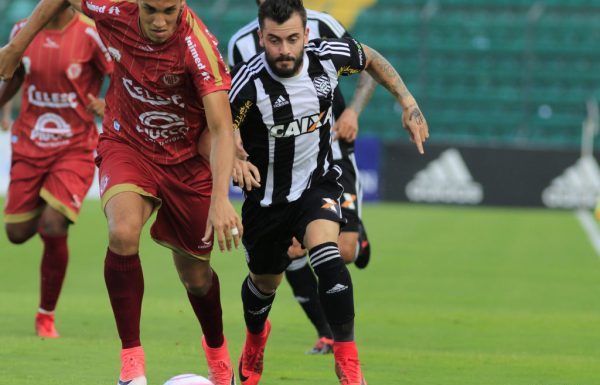 Jogadores de Figueirense (preto e branco) e Hercíllio Luz (vermelho) disputam a bola em direção à câmera