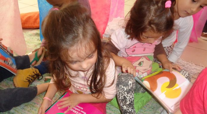 Meninas sentadas no chão com livros no colo
