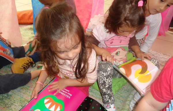 Meninas sentadas no chão com livros no colo