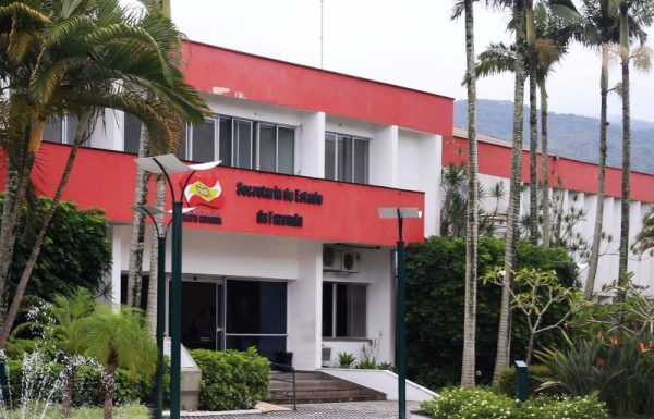 Imagem da fachada da Secretaria de Estado da Fazenda, com coqueiros e plantas à frente