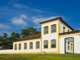 Imagem da fachada do museu; construção estilo açoriana: paredes em branco com janelas verdes