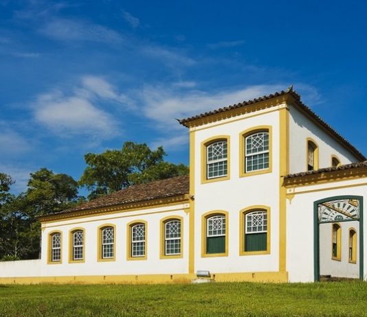 Imagem da fachada do museu; construção estilo açoriana: paredes em branco com janelas verdes