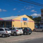 Fachada externa da unidade de saúde com carros estacionados à frente