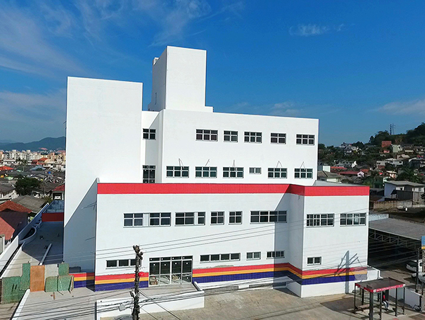 Vista do prédio branco de quatro andares tirada por um drone na altura da última janela