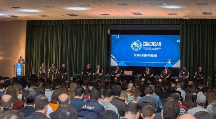 público sentado assistindo a uma palestra em um auditório