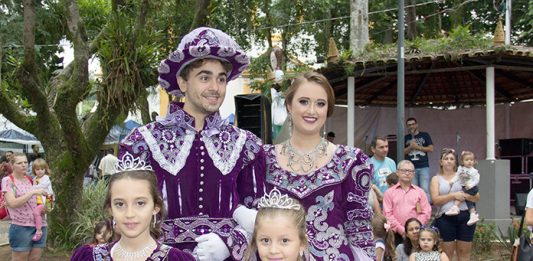 quatro pessoas (homem, mulher , menino e menina) vestidos de forma igual com trajes imperiais roxos sorridentes para a foto