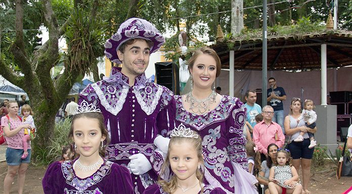 quatro pessoas (homem, mulher , menino e menina) vestidos de forma igual com trajes imperiais roxos sorridentes para a foto