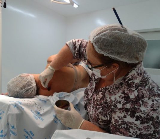 Florianópolis realiza primeiro mutirão de pequenas cirurgias mulher usando acessórios de higiene atende pessoa deitada em uma mesa cirúrgica