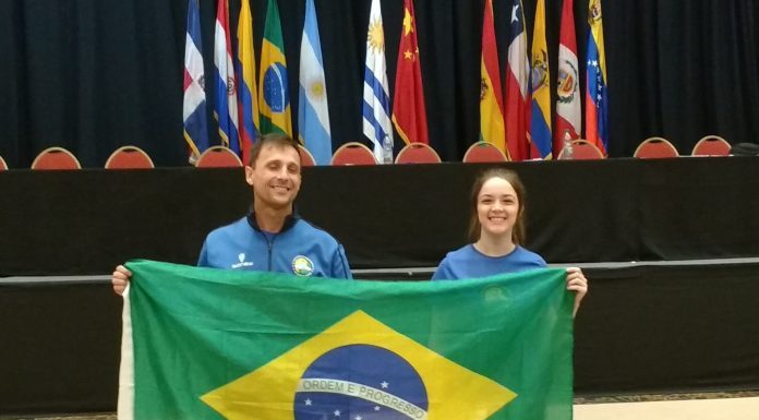 Homem e moça seguram a bandeira do Brasil