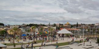 Vista superior do parque, com bastante gente em todos os brinquedos e quadras de esporte
