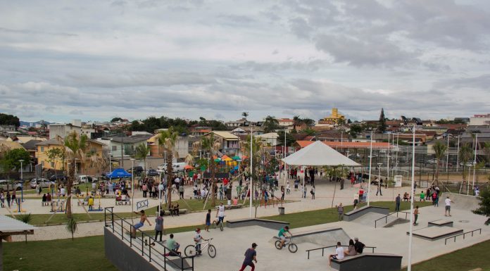 Vista superior do parque, com bastante gente em todos os brinquedos e quadras de esporte