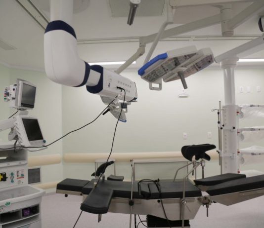Sala de cirurgia com equipamentos novos sobre uma cama; não há ninguém na foto