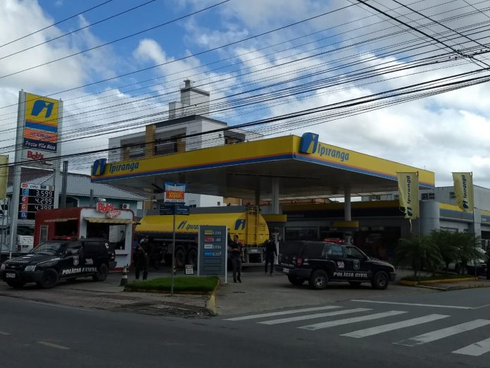 gasolina para veiculos oficiais posto de combustível com caminhão tanque e duas caminhonetes da polícia civil