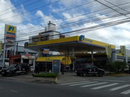 posto de combustível com caminhão tanque e duas caminhonetes da polícia civil