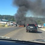 carro parado sobre a rodovia e à frente fumaça preta