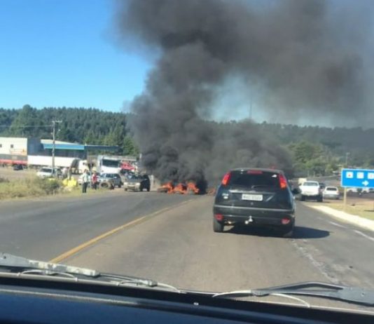 carro parado sobre a rodovia e à frente fumaça preta