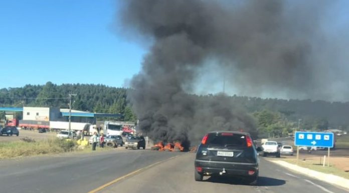 carro parado sobre a rodovia e à frente fumaça preta