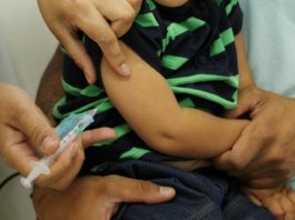 aplicação de vacina em braço de um menino