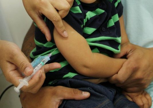 aplicação de vacina em braço de um menino
