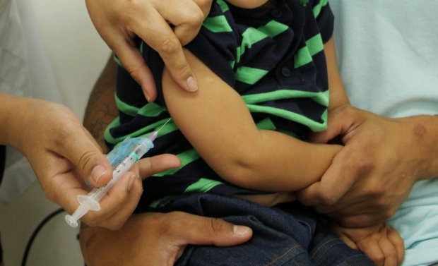 aplicação de vacina em braço de um menino