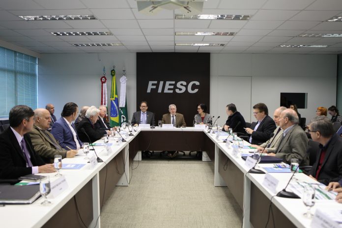 FS-1-2 pessoas sentadas em reunião numa grande bancada em U