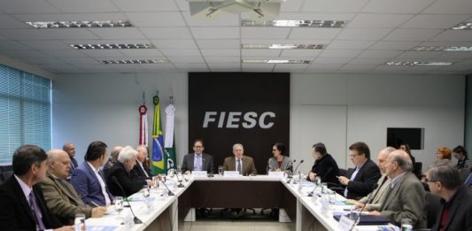 Fiesc debate propostas aos candidatos nas eleições 2018 pessoas sentadas em reunião numa grande bancada em U