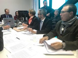 Juiz determina que cadeião não pode ser construído na Fazenda Santo Antônio Vista lateral de uma mesa em que estão sentadas a prefeita e demais acompanhantes com o procurador ao fundo em frente a um computador