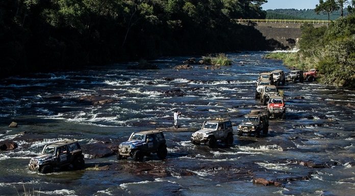 Comboio de jipes cruzando um rio em fila
