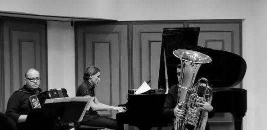 foto em preto e branco mostrando três músicos em um estúdio tocando gaita, piano e trombone