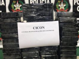 pacotes pretos empilhados com uma folha de papel A4 pendurada na frente escrita "Cicon - central de investigação do continente"