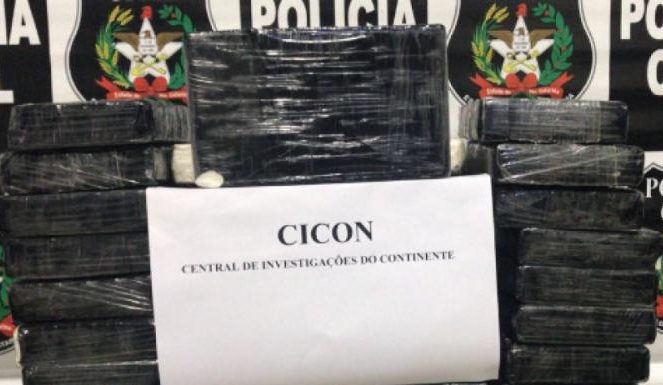 pacotes pretos empilhados com uma folha de papel A4 pendurada na frente escrita "Cicon - central de investigação do continente"