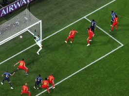 Uma Copa surpreendente goleira vista de cima, com amplo gramado preenchendo a foto, ondes estão os jogadores de frança e bélgica vendo a bola entrar e goleiro fazendo movimento