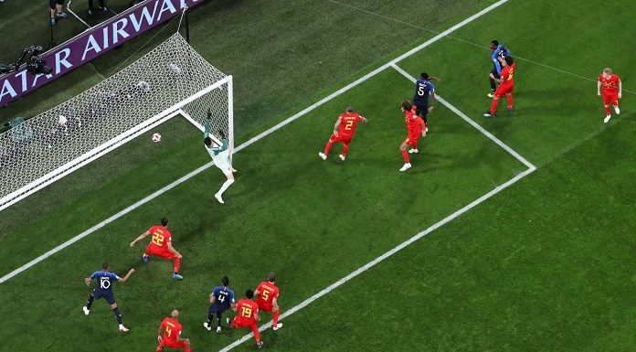 goleira vista de cima, com amplo gramado preenchendo a foto, ondes estão os jogadores de frança e bélgica vendo a bola entrar e goleiro fazendo movimento