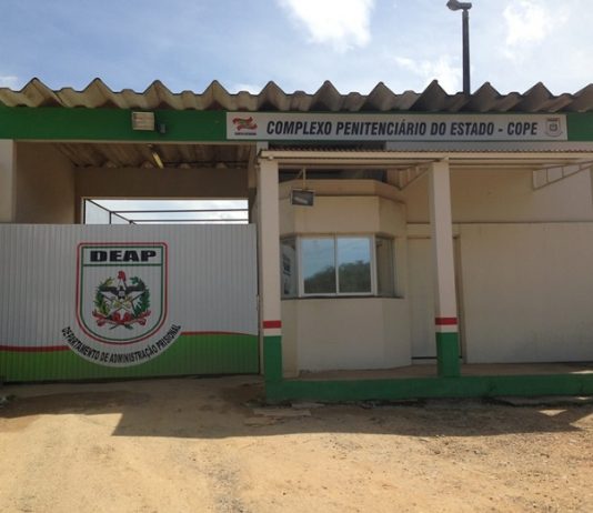 Fachada do portão principal de um centro prisional, com os logos do Deap