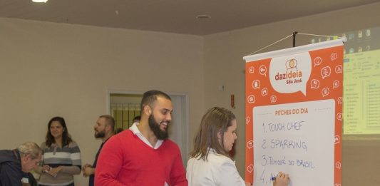 1º Encontro Dazideia São José reúne projetos e inspira novos negócios Mulher escreve lista em cartaz e homem olha enquanto ri