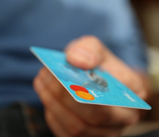Grupo com 200 cartões de crédito é detido em Jurerê close em uma mão masculina segurando cartão de crédito em direção à câmera