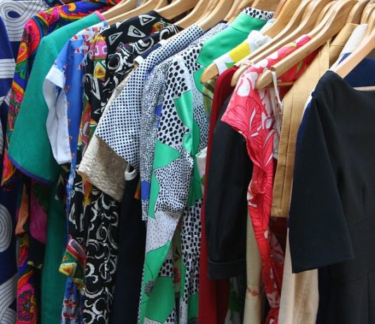 diversas peças de roupas penduradas juntas em cabideiro