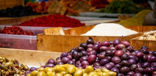 frutas e legumes de cores variadas dispostos em pilhas lado a lado