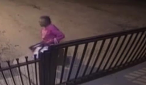 imagem de um vídeo que mostra o portão de entrada da casa com a idosa parada na rua em frente