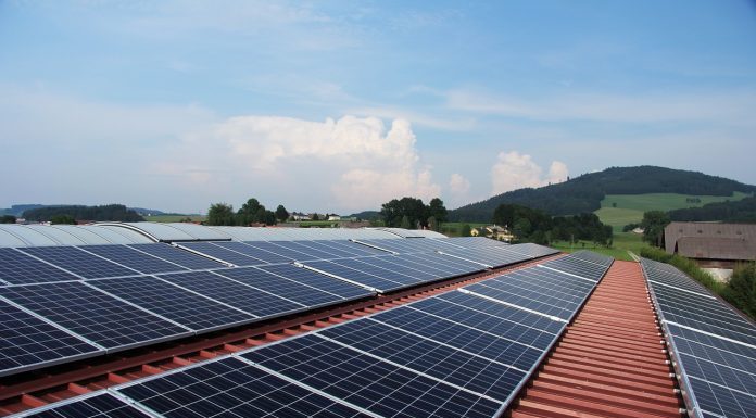 painéis solares em cima de um telhado com um grande céu limpo acima